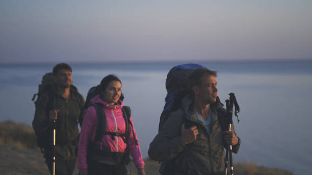 istock The three people with backpacks walking along the rocky coastline 1308594374
