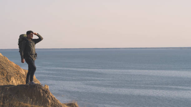 istock The man standing on the rocky sea coast 1308594556