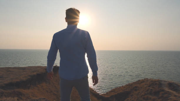 istock The handsome man walking along the sea shore 1308594597