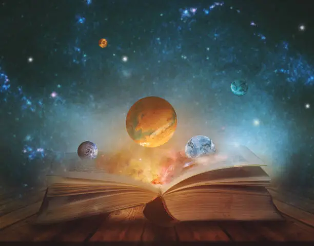 Photo of Book of the universe - opened magic book with planets and galaxies. Elements of this image furnished by NASA