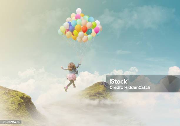 Little Girl Holding Colorful Balloons Jumping From One Mountain Top To The Other Successachievement Concept Fantasy Background With Copy Space Stock Photo - Download Image Now