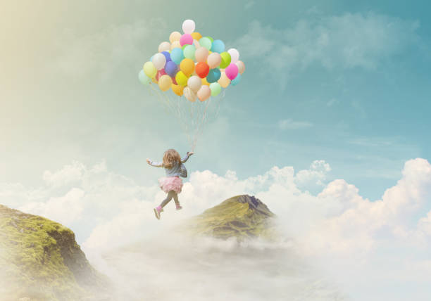 little girl holding colorful balloons, jumping from one mountain top to the other; success/achievement concept, fantasy background with copy space - vital force imagens e fotografias de stock