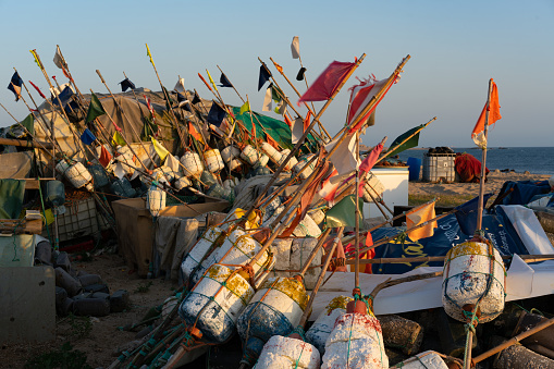 Alexandria, Egypt - June 21, 2023:Fisherman working at coast of Mediterranean Sea in Alexandria Harbor. The cityscape of Alexandria and fisherman boats can be seen in the background.