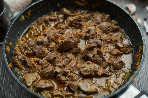 istock fried chicken liver with onions and carrots in a black pan close-up 1308597464