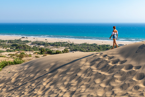Young woman walking on the dunes. Patara Sand dunes, Turkey.