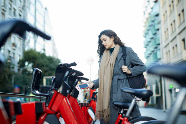 A young woman using an app to rent a shared bike.