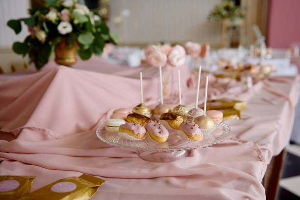 istock Candy bar served with macaroons, choux pastry and cake pops in restaurant, copy space. Dessert table for party  pink color. Holiday concept 1308605627