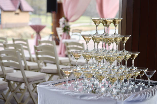 stack of champagne glasses on table on wedding party reception outdoors. champagne tower. holiday concept - champagne champagne flute wedding glass imagens e fotografias de stock