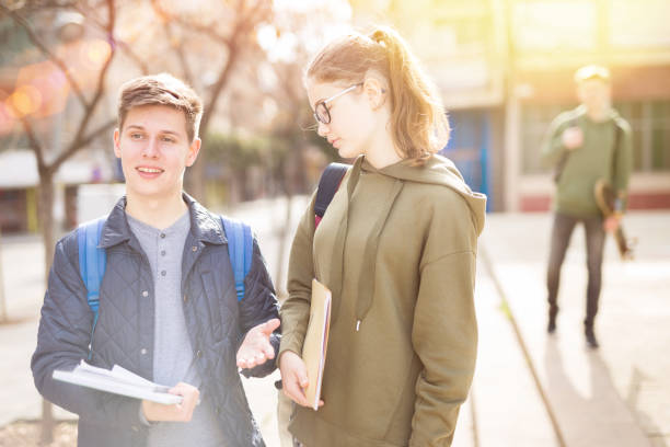 istock Two students discuss past lessons at college on the street 1308607186