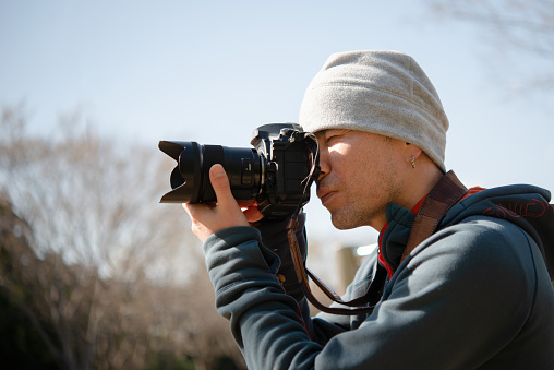 Men take photos with a single-lens reflex camera