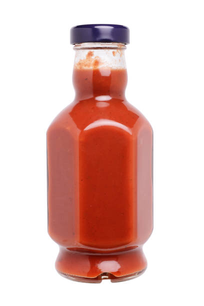 istock Glass bottle with ketchup, unusual shape. Close-up on a white background 1308609204