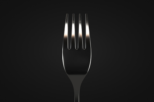 Table fork close up. Dark background. Design element