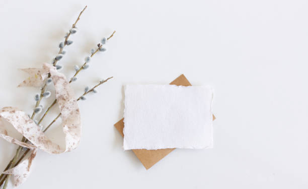istock Spring still life.Easter composition with goat willow, pussy willow or great sallow, blank paper sheet mockup, scissors, and silk ribbon on wooden table background.Top view. 1308612387