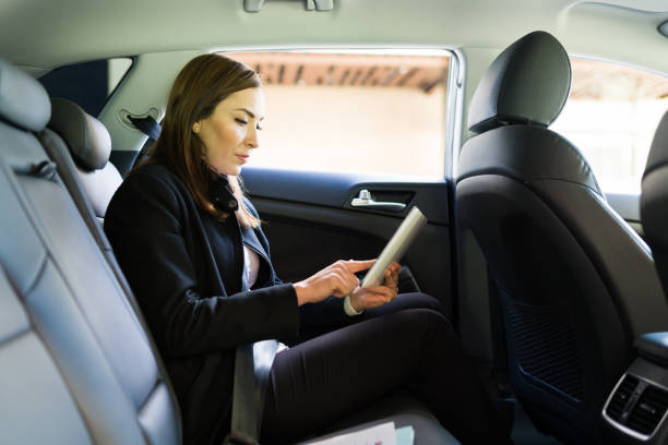 istock Professional woman holding a touchscreen tablet in the car 1308613450