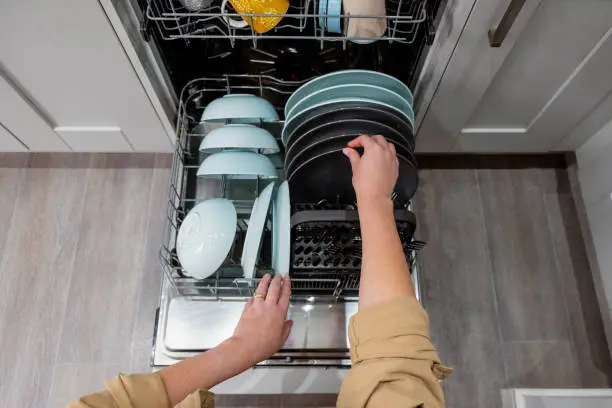 Photo of Point of View of a Woman Emptying the Dishwasher
