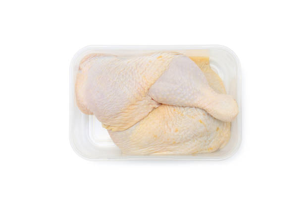 istock Raw chicken leg in plastic tray isolated on white background with clipping path 1308614766