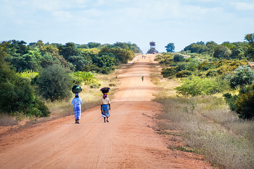African women walking along the sand road to Mapai in Mozambique.