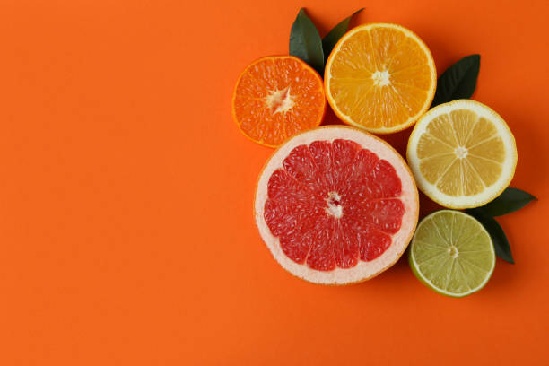 istock Ripe citrus with leaves on orange background 1308617799