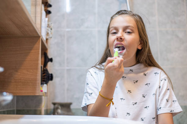 istock Little girl in brushing teeth a bathroom 1308618139