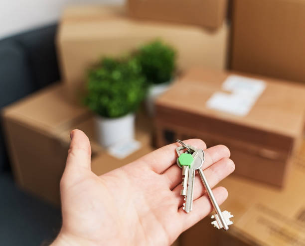 istock Hand with house key. Real estate and moving concept. 1308618404