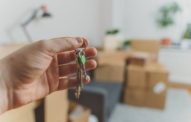 istock Hand with house key. Real estate and moving concept. 1308618410