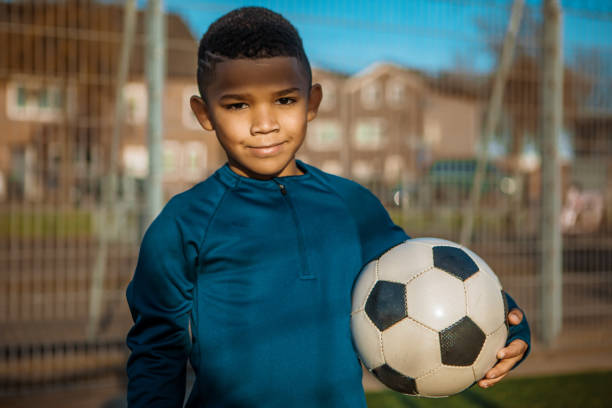 istock A young black boy training hard on the football pitch 1308619556