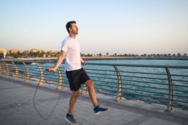 istock Man doing a jumping rope exercise at sunset by the seaside 1308620704
