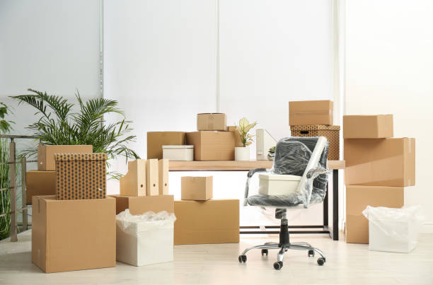 cajas de cartón y silla empacada en la oficina. día de mudanza - moving fotografías e imágenes de stock