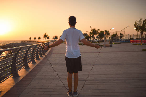 istock Man doing a jumping rope exercise at sunset by the seaside 1308620771