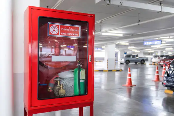 Photo of Fire Hose Reel box in the corner of Car Parking., The White Thai Language letter in the middle of the red box means FIRE HOSE REEL.