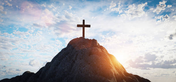 istock Cross on mountain peak at sunset christian religion 1308622979