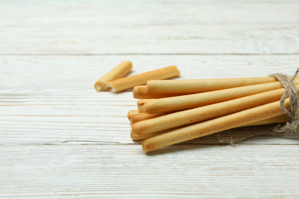 istock Tasty grissini breadsticks on white wooden background 1308623215