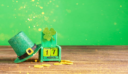 Calendar with the date March 17. Leprechaun hat and shamrock clover on a green background. St. Patrick's Day celebration concept. Horizontal frame for copy space