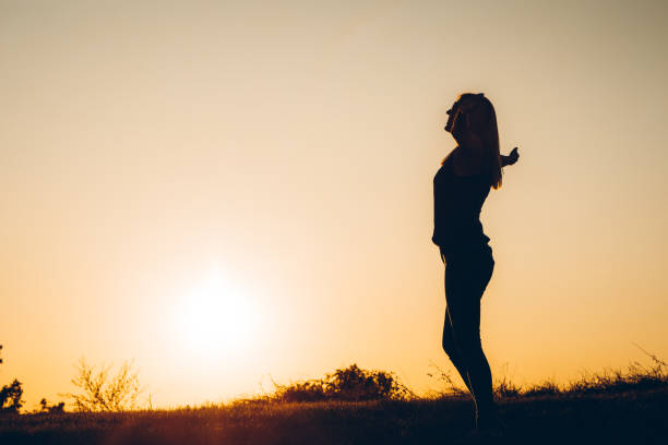 istock Female silhouette at sunset 1308629120