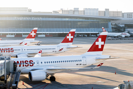 Zurich, Switzerland - March 23, 2021: Overview of Zurich Airport with Swiss International Air Lines airplanes parked at the terminals. Swiss International Air Lines (SWISS) is the airline of Switzerland, serving more than 100 destinations from Zurich and Geneva and carrying more than 16 million passengers a year.