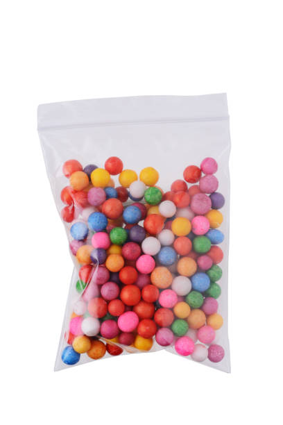 istock Colored objects made of round plastic for crafts and decoration in a plastic transparent bag. Close-up on a white background 1308631686