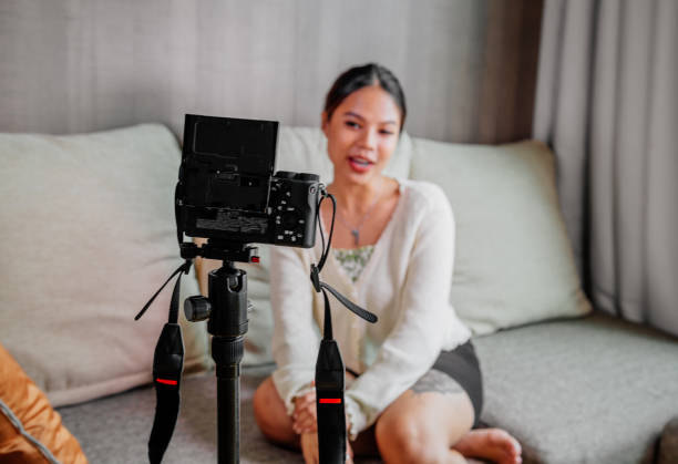 istock Asian blogger, podcaster or vlogger looking at camera and talking on video shooting with technology. Social media influencer people or content maker concept in relax casual style at home 1308633582