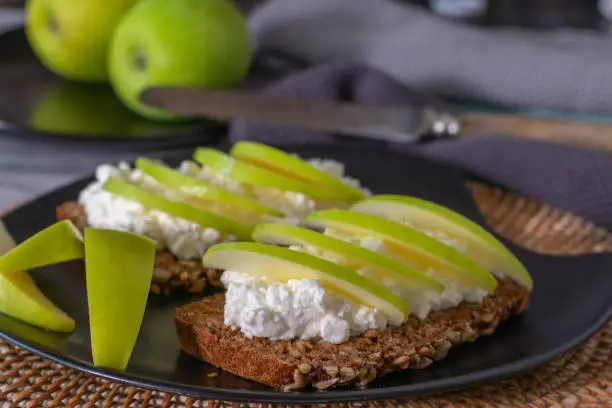 healthy and low fat vegetarian open sandwich with cottage cheese and sliced green apples served on a plate at home
