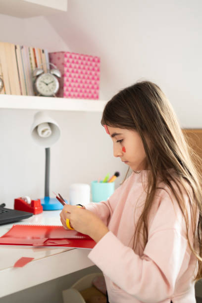 istock Littel girl cutting the plastic notebook 1308635075