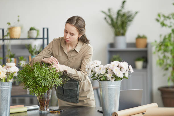 istock Young Woman Caring for Flowers in Workshop 1308635404