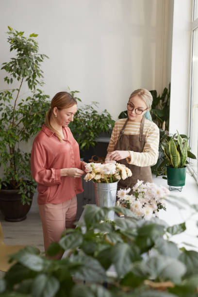 istock Two Young Women Creating Compositions in Flower Shop 1308635432