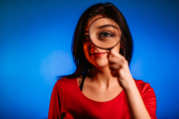 Woman looking through magnifying glass