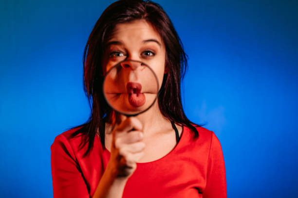 istock Woman making a silly face under magnifying glass 1308635908