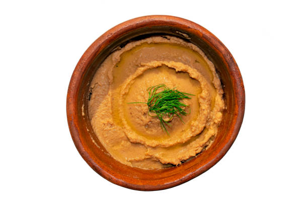 istock Peeled fava beans mashed plain in a brown bowl isolated on white background. Top view. 1308636347