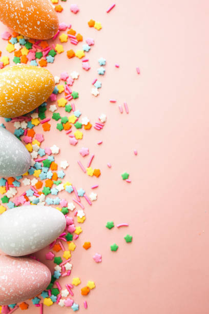 istock White, grey and yellow eggs on pink background with colourful sprinkles. Easter holiday background. 1308637370