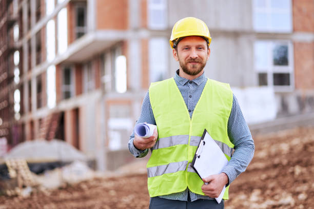 istock Portrait of an engineer holding a blueprint at a construction site 1308637417