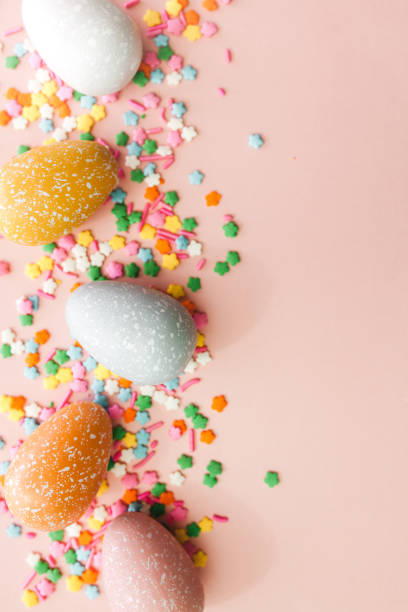 istock White, grey and yellow eggs on pink background with colourful sprinkles. Easter holiday background. 1308637441