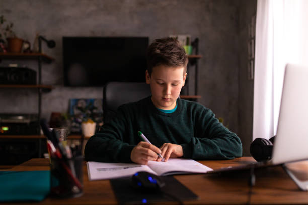 istock During his online class, 9 year old schoolboy, writing down the teacher lecture to help him latter when he doing the homework 1308637802