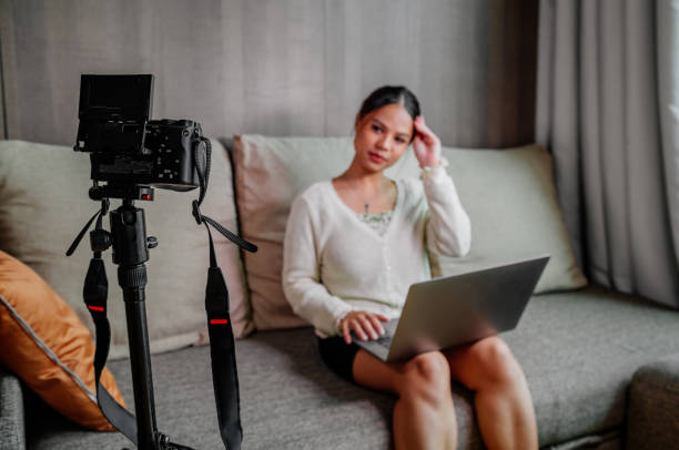 istock Asian blogger, podcaster or vlogger looking at camera and talking on video shooting with technology. Social media influencer people or content maker concept in relax casual style at home 1308638807