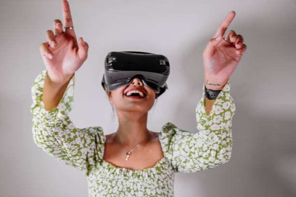 istock Asian Woman looking through virtual reality device at home. Augmented reality, game, future technology concept.VR 1308639073